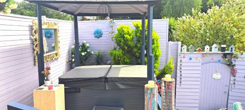 an outdoor pergola with a table and an umbrella at Lily Lake Lodge in Chelmsford
