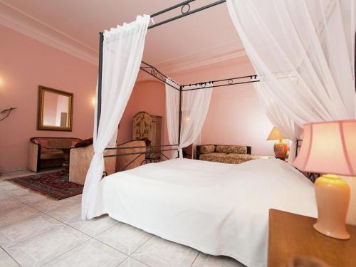 a bedroom with a white bed with curtains at Triestewitz Hideaway in Saxony in Arzberg