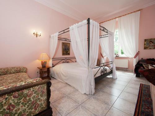 a bedroom with a canopy bed and a couch at Triestewitz Hideaway in Saxony in Arzberg