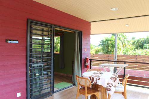 a room with a table and chairs on a balcony at Vai'Ute'Ute Lodge, Raiatea in Tevaitoa