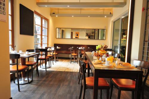 a dining room with tables and chairs in a restaurant at Lint Hotel Köln in Cologne