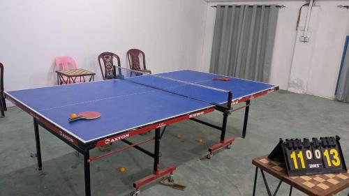 a ping pong table in a room with chairs at Rihiveli inn 