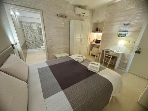 a bedroom with a large bed and a bathroom at B&B SANGIORGIO Green living in Melpignano