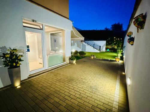an empty patio with a door to a house at night at B&B SANGIORGIO Green living in Melpignano