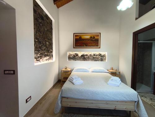 a bedroom with a bed and two pictures on the wall at Beautiful Etna's view in San Giovanni la Punta