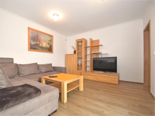 a living room with a couch and a flat screen tv at Bodenwöhr Lakeside Gem in Bodenwöhr