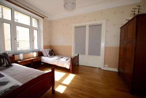 een slaapkamer met twee bedden en een raam bij Gites de l'Austrasie in Metz