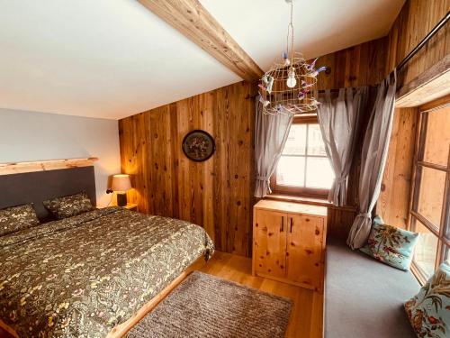 a bedroom with wood paneling and a bed and a window at SEPPKEUSCHE - historisches Chalet mit Zirbensauna und Hotpot in Turracher Hohe