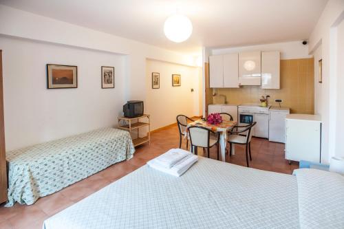 a room with two beds and a table and a kitchen at Eolcalandra Case Per Vacanza in Canneto