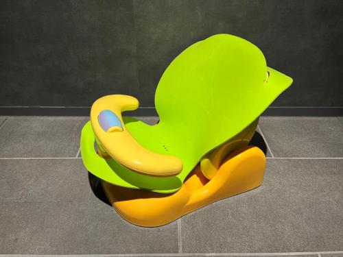 a green and yellow chair sitting on a tile floor at hotel tou nishinotoin kyoto in Kyoto