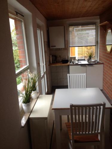a small kitchen with a white table and chairs at Ferienhaus Ralf in Zinnowitz