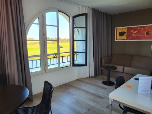 a living room with a couch and a large window at Adagio Serris Val d'Europe in Serris