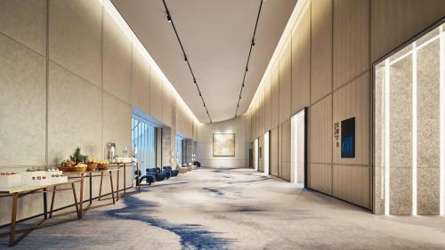 a hallway with tables and chairs in a building at Crowne Plaza Hangzhou Riverside by IHG in Hangzhou