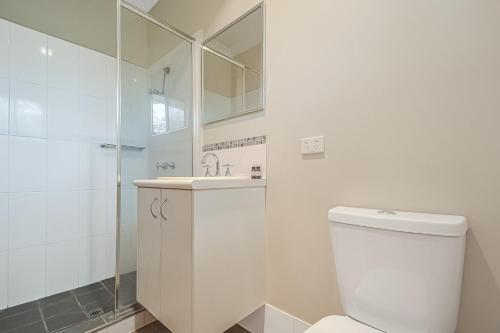a bathroom with a toilet and a sink and a shower at Terrific Townhouse 3x2 in CBD in Port Hedland