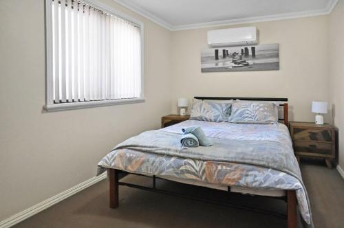 a bedroom with a large bed with a window at Pilbara Cabin Affordable 1x1 in Port Hedland