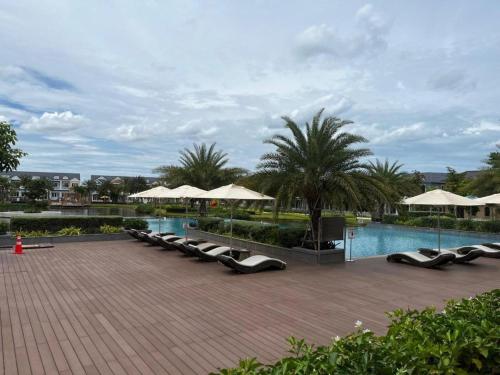 a swimming pool with lounge chairs and umbrellas at Sandy Villa in Phan Thiet