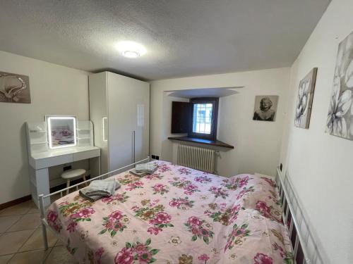 a bedroom with a bed and a desk and a window at Valmaison - your cottage in the historic center in Aosta
