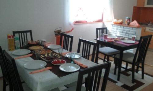 a dining room table and chairs with food on it at Apartment Melissa in Rakovica