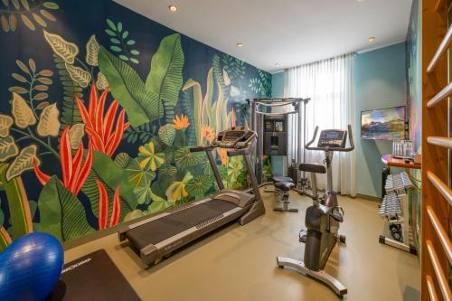 a gym with a mural of plants and a treadmill at Austria Classic Hotel Wien in Vienna