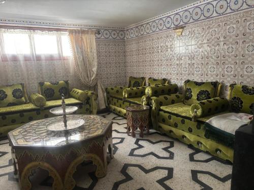 a living room with green furniture and a table at Dar Fatima fessia in Fès
