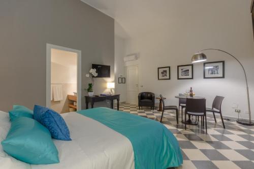 a bedroom with a bed and a dining room at Hotel Moderno in Trapani