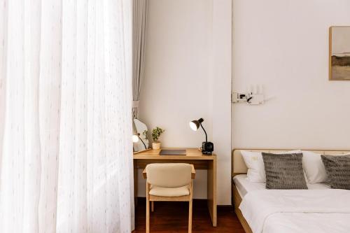 a bedroom with a desk and a bed and a table at The Hammond Saigon 3 in Ho Chi Minh City