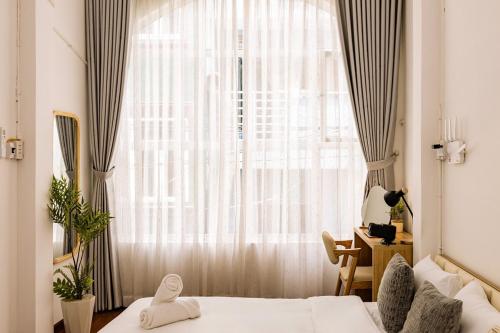a bedroom with two beds and a large window at The Hammond Saigon 3 in Ho Chi Minh City