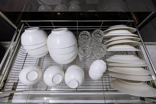 a bunch of white vases and plates in a shelf at The Hammond Saigon 3 in Ho Chi Minh City