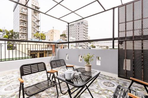 an apartment with a balcony with a table and chairs at The Hammond Saigon 3 in Ho Chi Minh City
