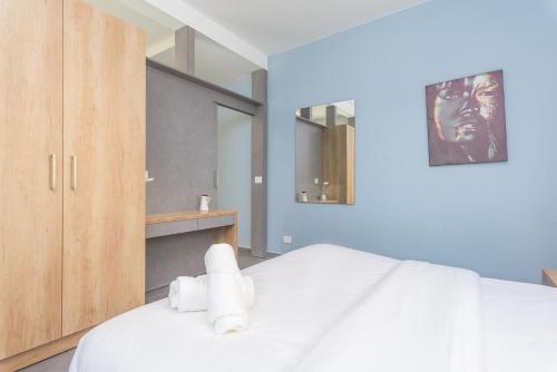 a bedroom with a white bed with towels on it at Grey - Elegant Apartments in Awkar in Dbayeh