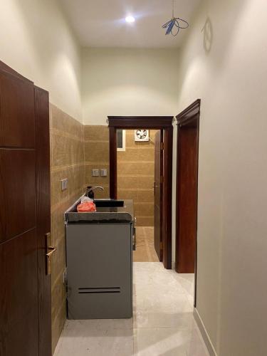 a hallway of a bathroom with a sink in a room at رمال العلا 1 Sand AlUla 1 in Quai