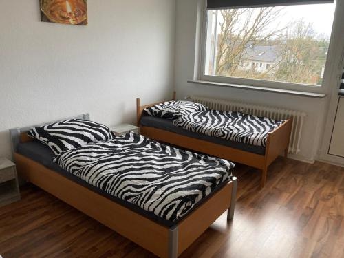 two beds sitting in a room with a window at Grace in Wathlingen