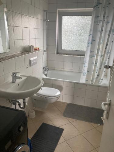 a bathroom with a toilet and a sink and a tub at Grace in Wathlingen
