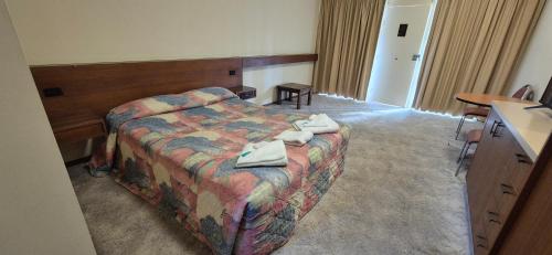 a hotel room with a bed with towels on it at The Molong Motor Inn in Molong