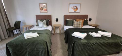 two beds in a room with towels on them at The Molong Motor Inn in Molong