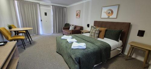 a hotel room with a bed with towels on it at The Molong Motor Inn in Molong