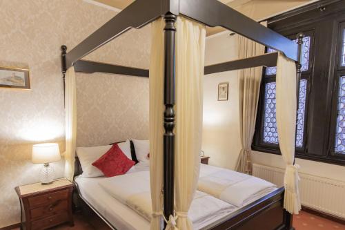 a bedroom with a canopy bed and a window at Hotel Weiler in Oberwesel
