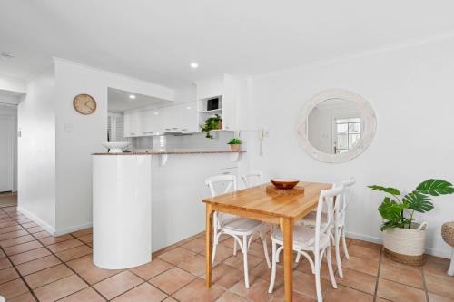a kitchen and dining room with a wooden table and chairs at Villa Aqua 6 - Riverfront Noosaville in Noosaville