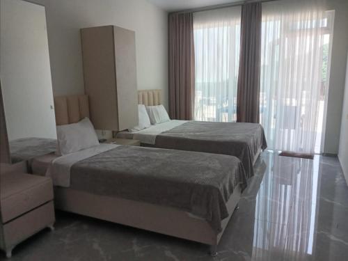 a hotel room with two beds and a window at Goga Guest House in Kvariati