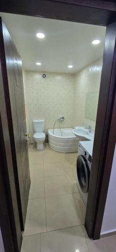 a bathroom with a tub and a toilet and a sink at vapollo apartment in Batumi