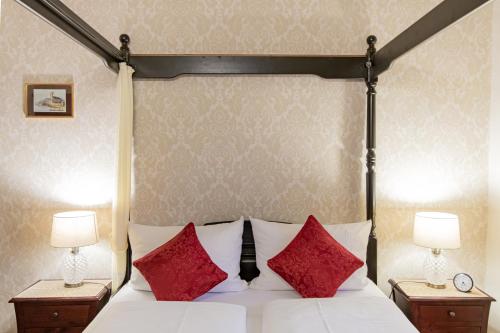 a bedroom with a bed with red pillows at Hotel Weiler in Oberwesel