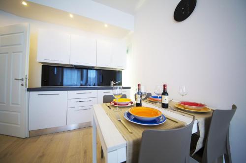 eine Küche mit einem Tisch mit Tellern und Weingläsern in der Unterkunft TwoBros Apartment in Florenz