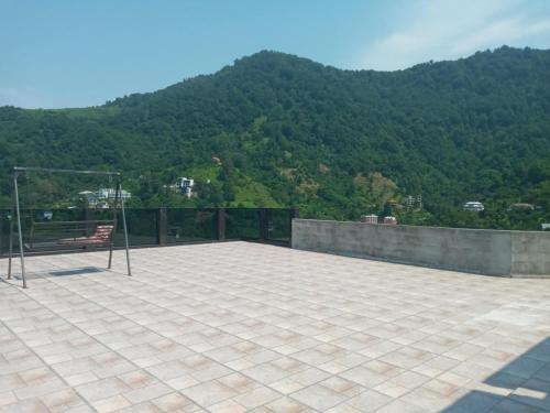 a patio with a bench and mountains in the background at Goga Guest House in Kvariati