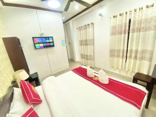 a hospital room with two beds and a tv at Luangprabang Suankeo boutique Villa in Luang Prabang