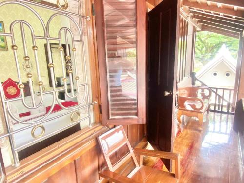 a chair sitting in front of a door with a window at Luangprabang Suankeo boutique Villa in Luang Prabang