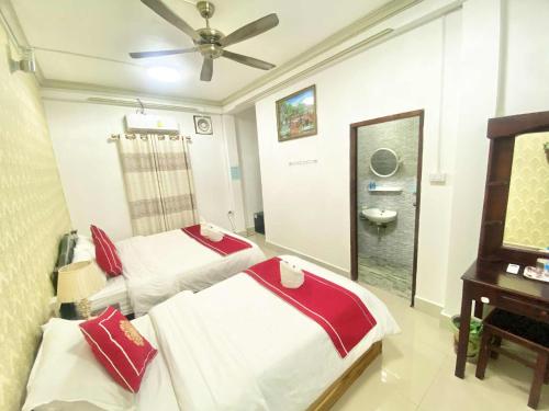 a bedroom with two beds and a sink and a mirror at Luangprabang Suankeo boutique Villa in Luang Prabang
