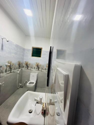a white bathroom with a sink and a toilet at Rathnayaka Family & Holiday Home in Anuradhapura