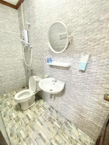 a bathroom with a toilet and a sink and a mirror at Luangprabang Suankeo boutique Villa in Luang Prabang