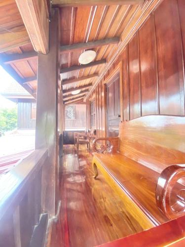 a room with a bed and wooden walls at Luangprabang Suankeo boutique Villa in Luang Prabang