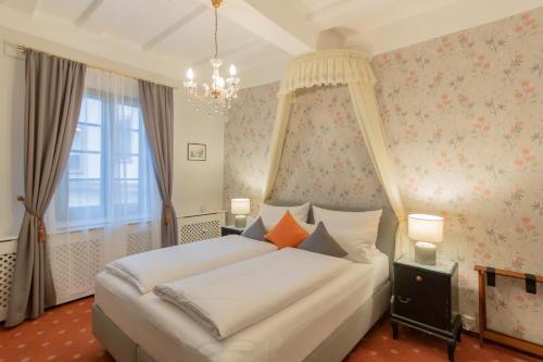 a bedroom with a white bed with a canopy at Hotel Weiler in Oberwesel